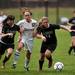 Dexter senior Olivia Vollmers races against Huron players Brenna Barton and Emma Mees for a ball on Tuesday, April 23. Daniel Brenner I AnnArbor.com